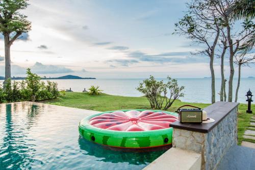 a swimming pool with a pink and green inflatable bed at 2H RESORT KOH SAMUI in Mae Nam