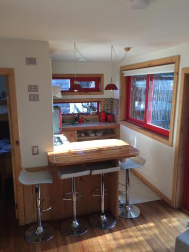 a kitchen with a table and stools in a tiny house at Almabosque Cabañas in Puerto Varas