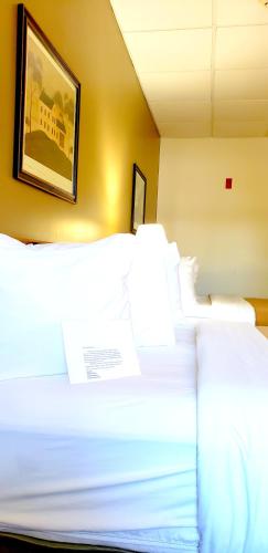 a bedroom with two white beds with a picture on the wall at Lodging on the Square in Berlin