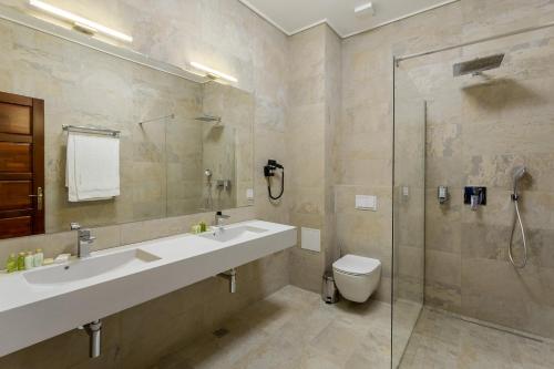 a bathroom with a sink and a shower and a toilet at Lahovary Palace Hotel in Bucharest