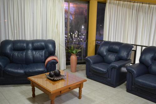 a living room with blue leather furniture and a coffee table at HOTEL CENTER in Reconquista