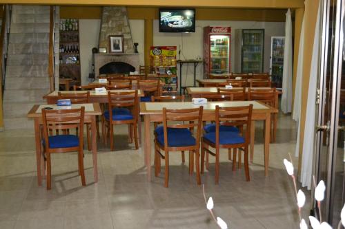 um restaurante com mesas e cadeiras de madeira e uma lareira em HOTEL CENTER em Reconquista