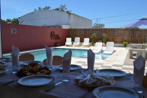 una mesa con platos y utensilios junto a una piscina en HOTEL CENTER en Reconquista