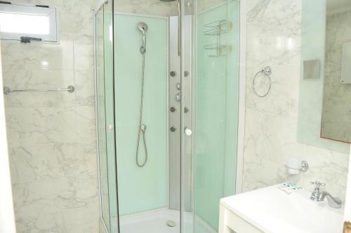 ein Badezimmer mit Glasdusche und Waschbecken in der Unterkunft Hotel Frasi's in San Clemente del Tuyú