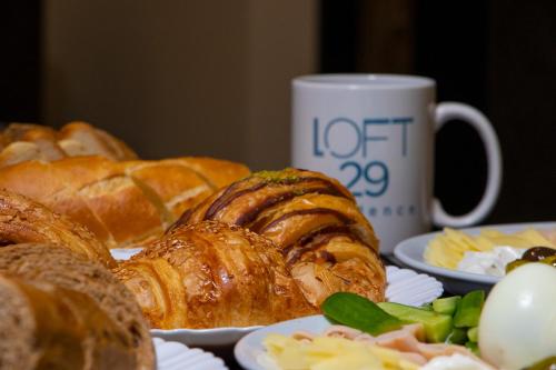 uma mesa com pratos de pastelaria e uma chávena de café em Loft 29 Residence em Beirute