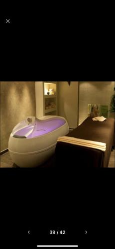a bathroom with a purple bath tub next to a bed at Terra Complex SPA apartment 1 bedroom suite in Razlog