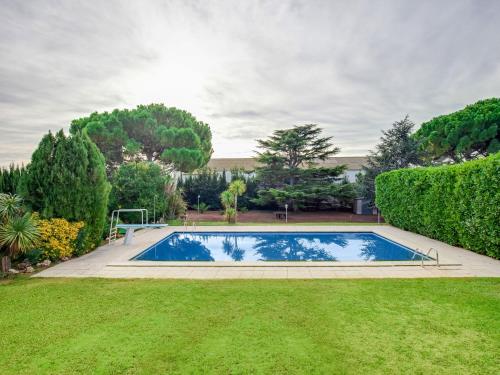 ein Schwimmbad in der Mitte eines Gartens in der Unterkunft Belvilla by OYO Bon Relax Espai in Sant Pere Pescador