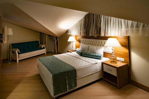ein Schlafzimmer mit einem großen Bett und einem Sofa in der Unterkunft Exelans Hotel in Fethiye