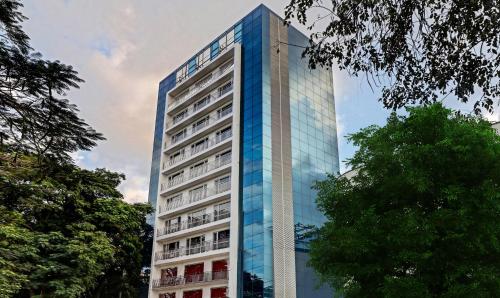 a tall blue building with trees in front of it at Treebo Trend Park in Trivandrum