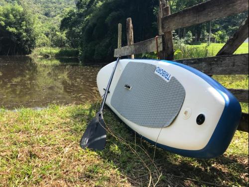 a boat sitting on the grass next to a body of water at Espaço Casa na Rocha in São José dos Campos