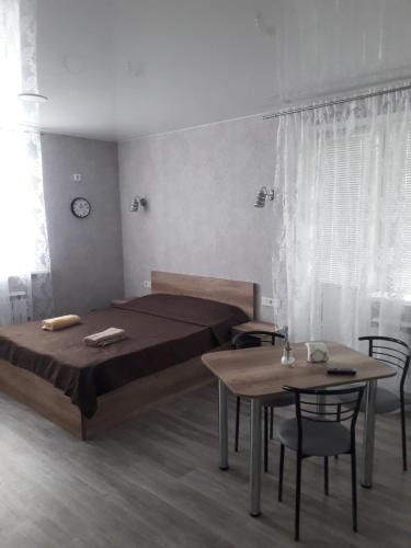 a bedroom with a bed and a table and chairs at Studio on Stefan 37 in Bălţi