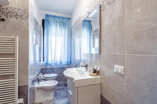 a bathroom with a sink and a toilet and a mirror at Le Terrazze in Follonica