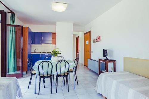 a dining room with a table and chairs and a kitchen at Le Terrazze in Follonica