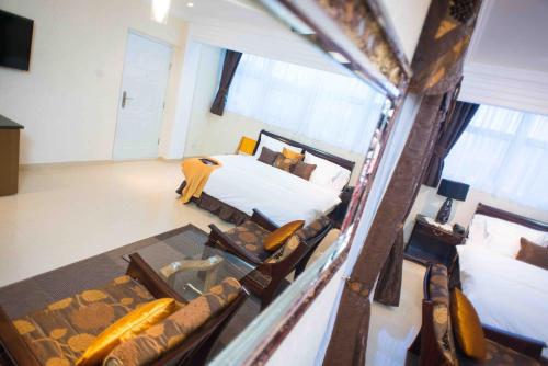 a view of a bedroom with a bed and chairs at The Ritzz Exclusive Guest House in Accra