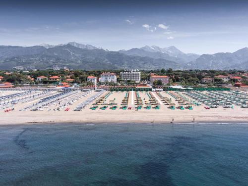 - une plage avec beaucoup de chaises et de parasols dans l'établissement Stanza Angiolina, à Forte dei Marmi