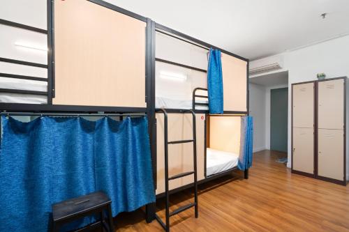 Habitación con 2 literas y cortinas azules. en Amethyst Dorm KLCC en Kuala Lumpur