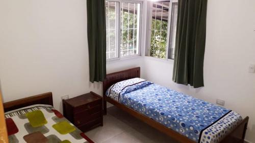 una camera con 2 letti singoli e 2 finestre di Casa con pileta privada a Tanti