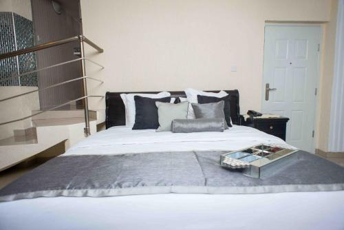 a bedroom with a large bed with a tray on it at The Ritzz Exclusive Guest House in Accra
