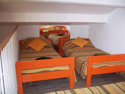 - 2 lits dans une chambre avec des chaises orange dans l'établissement Mas de l île rousse, à Bandol