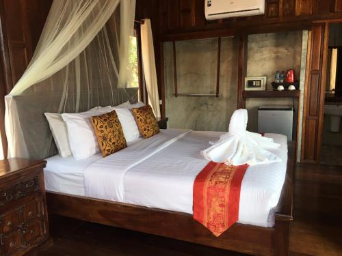 a bedroom with a bed with white sheets and pillows at Tara Beach Resort Udonthani in Udon Thani