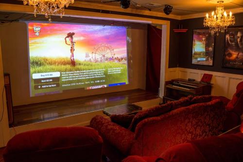 a large projection screen in a room with two couches at Chiltern Inn in Bar Harbor