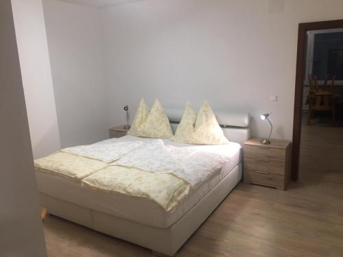 - une chambre avec un lit doté de draps et d'oreillers blancs dans l'établissement Ferienwohnung neben dem Schloss Porcia, à Spittal an der Drau
