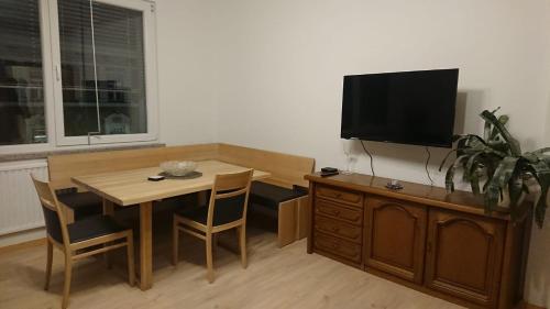 a living room with a table and a television on a cabinet at Ferienwohnung neben dem Schloss Porcia in Spittal an der Drau
