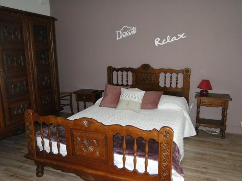 um quarto com uma cama de madeira com almofadas em Appartement été et hiver 1 à 5 pers. Cauterets em Cauterets