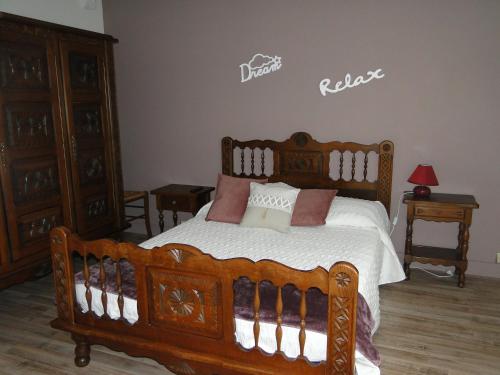 a bedroom with a wooden bed with pillows on it at Appartement Ilhéou été et hiver 1 à 5 personnes Cauterets in Cauterets
