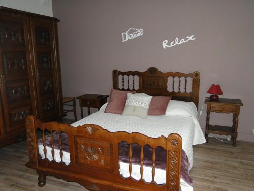 a bedroom with a wooden bed with pillows on it at Appartement été et hiver 1 à 5 pers. Cauterets in Cauterets