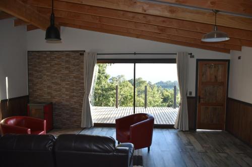 a living room with a couch and a large window at El Granero de la Abuela in Futrono