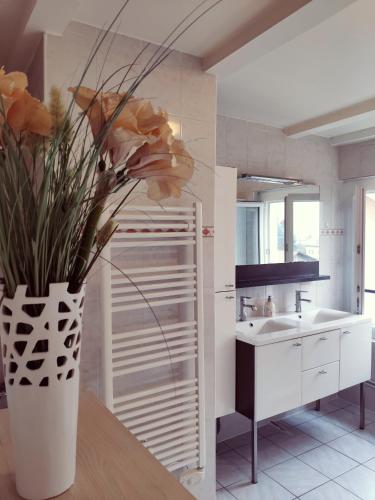 a kitchen with a vase of flowers on a table at Au bord du Foron in Scionzier