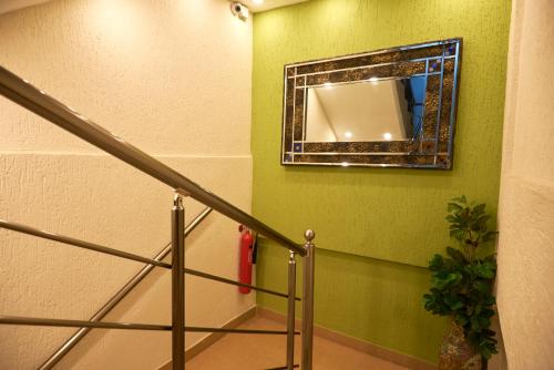 a mirror on a green wall next to a staircase at The Ritzz Exclusive Guest House in Accra