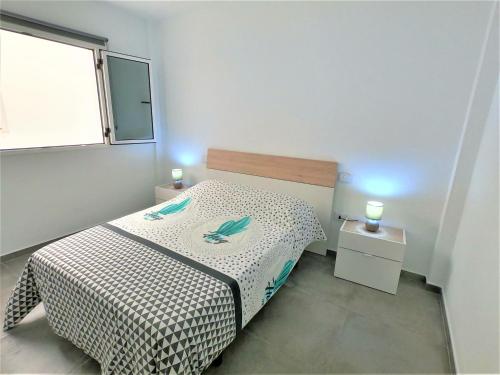 a small bedroom with a bed and a window at C4 Ocean Holiday Home - Puerto del Rosario in Puerto del Rosario