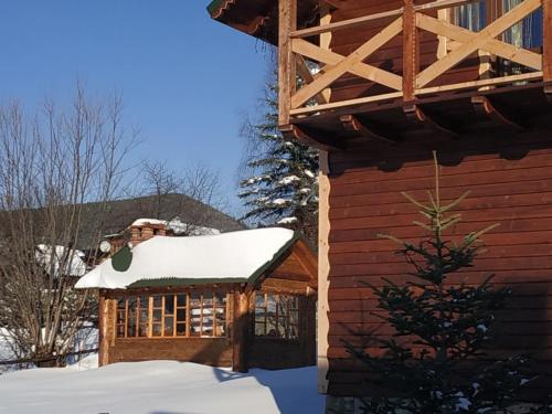 a log cabin with snow on the roof at Dobryi Hutsul 2 in Mykulychyn