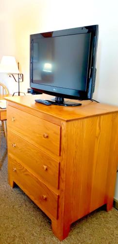 a tv sitting on top of a wooden dresser at Lodging on the Square in Berlin