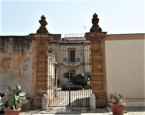 um portão ornamentado em frente a um edifício em appartamentino in villa settecentesca em Bagheria