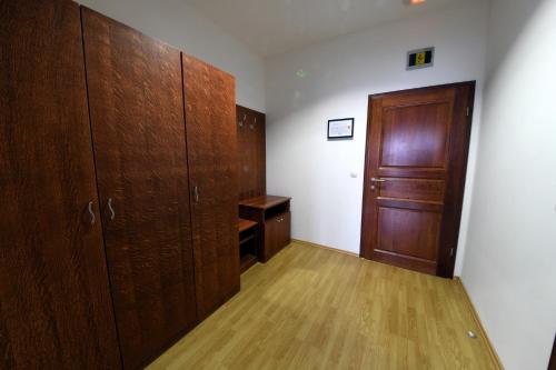 an empty room with wooden cabinets and a door at Apartments & Rooms Krizevci in Križevci