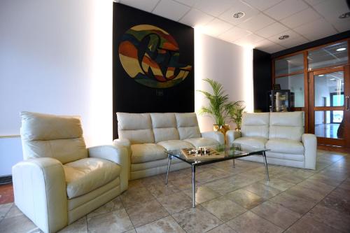 a living room with two couches and a coffee table at Apartments & Rooms Krizevci in Križevci