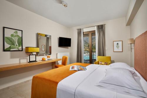 a hotel room with a large bed and a desk at Sempre Viva Suites in Monemvasia