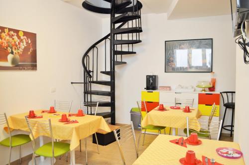 una habitación con mesas y sillas y una escalera de caracol en Casa34, en Ragusa