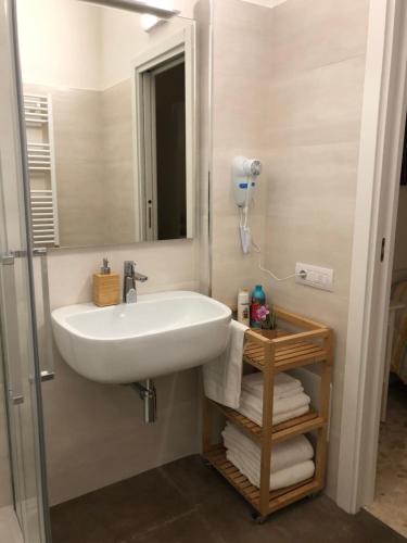 a bathroom with a sink and a mirror and towels at B&b Il Bacio in Modugno