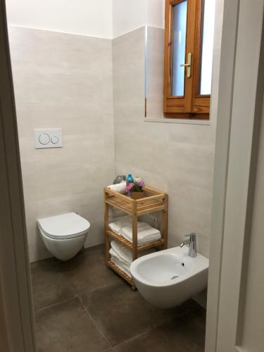a bathroom with a white toilet and a sink at B&b Il Bacio in Modugno