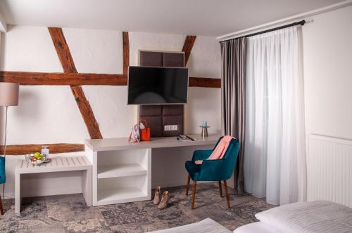 a bedroom with a white desk and a blue chair at Hotel Schuberths am Schloss in Buttenheim