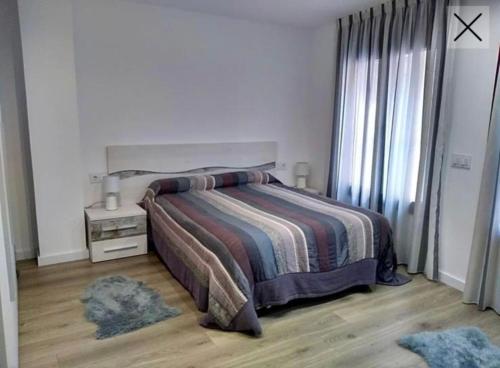 Schlafzimmer mit einem Bett, einem Tisch und einem Fenster in der Unterkunft Apartamento totalmente reformado en 1ª linea in Palamós