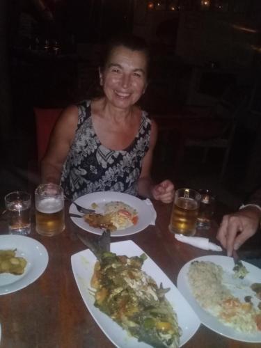 a woman sitting at a table with plates of food at The Alpha Monkey hotel & Tree house in Tangalle