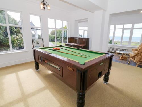 a living room with a pool table and windows at Brynmorwydd in Aberdyfi