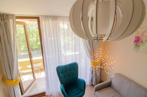 a living room with a blue chair and a window at Depto primera línea de playa para 5 personas in Villarrica
