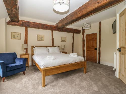 a bedroom with a bed and a blue chair at Copmanthorpe Hall in York