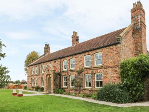an old brick building with a grass yard at Copmanthorpe Hall in York